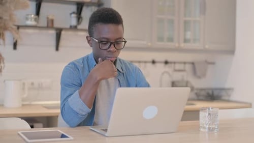 Young Adult Using Laptop Computer in Kitchen