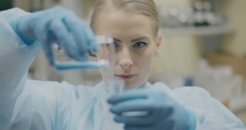 Woman Scientist Mixing Liquid in Laboratory Beaker