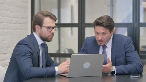Businessmen Discussing Plans at Office Table