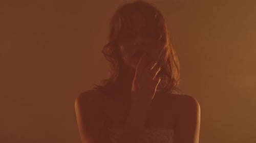 Mysterious Woman Posing in a Smokey Amber Studio