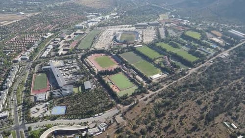 High altitude panning over sporting complex and residential area