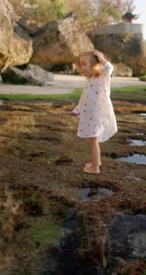 Little Child Girl Playing on Ocean Shoreline Happy Childhood with Sunset Sunshine