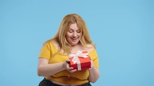 Excited Woman Shakes Birthday Gift