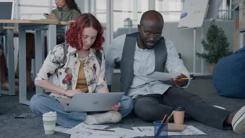 Colleagues Working on Floor in Open Office