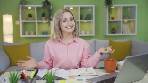 Young university girl at home looking at camera and giving lecture.