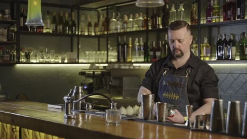 A Bartender Makes a Cocktail with Smoke at the Bar
