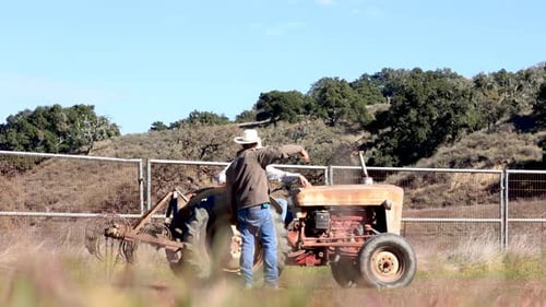 Men Working on a Red Vintage Tractor