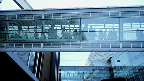 Business People Crossing Inside Glass Hallway Corridor