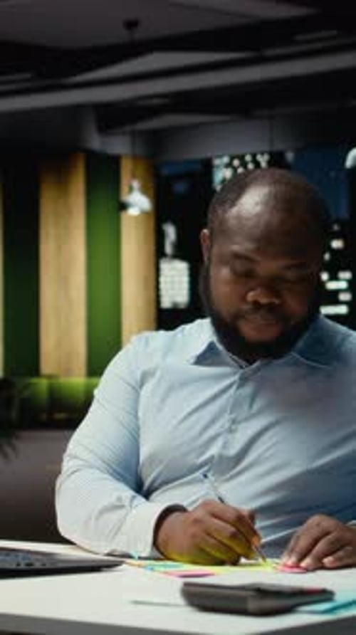 Vertical Video African American Office Worker Placing a Sticky Note on His Laptop As a Reminder
