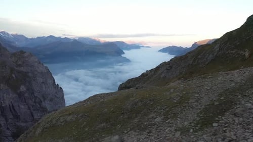 Drone shot flying sideways to the left, showing rocks, stones and pebbles on the slope of the mounta