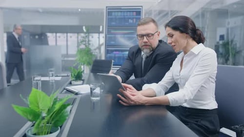 Business Colleagues Discussing Data on a Tablet Device