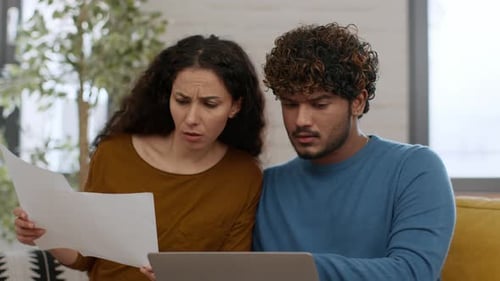 Junge besorgte Frau und Mann studieren Finanzberichte von einer Bank und lesen Steuerbescheinigungen