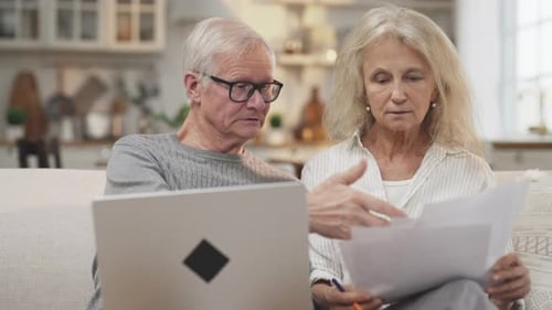 Senior Couple Working Together at Home with Laptop