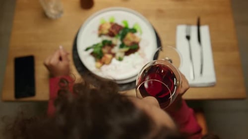 Woman enjoying luxury restaurant meal and wine glass at fancy evening bar table