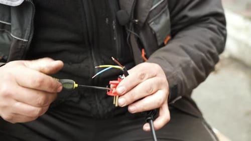 Adult Connects Power Cord Wiring with Screwdriver