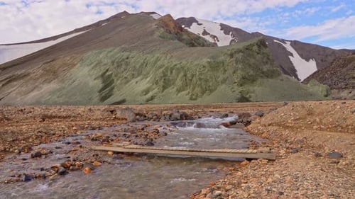 Fixed wide view of the river descending from Brennisteinsalda in Landmannalaugar, Iceland, featuring