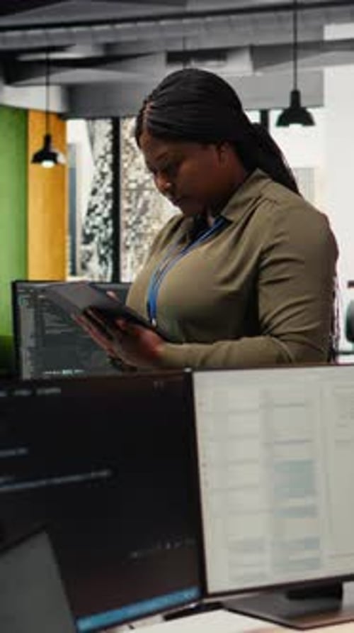 Вертикальный видеопортрет улыбающегося инженера, работающего в офисе с использованием специализированного оборудования искусственного интеллекта