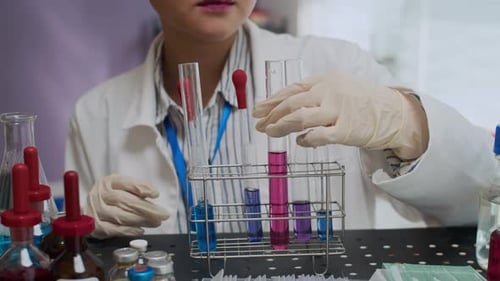 Young Adult Scientist Examining a Test Tube in Lab