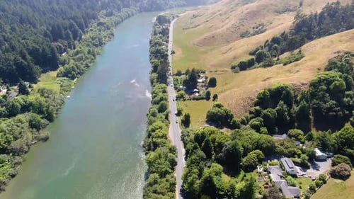 Aerial video of a country landscape with a river channel in the middle, surrounded by greenery and m