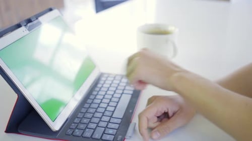 Young caucasian woman in her 30s using her tablet to be online with green screen