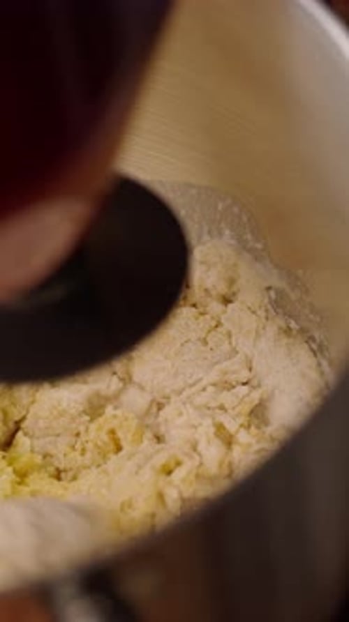 Mixing ingredients with metal beaters in kitchen