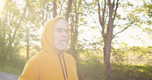 Close Up of Caucasian Senior Handsome Pensioner Sportsman Having Workout Running Outside on Street