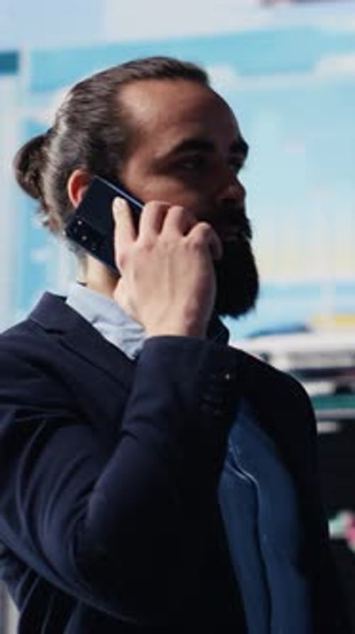 Vertical Video Male Entrepreneur Taking a Phone Call to Share Insight on KPI Metrics