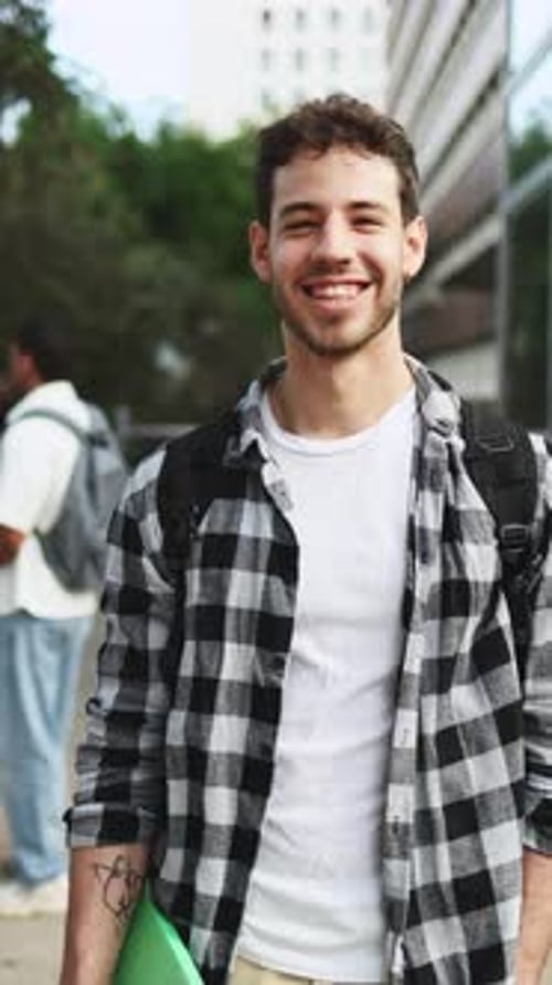 Smiling Young Man with Backpack on Urban Campus