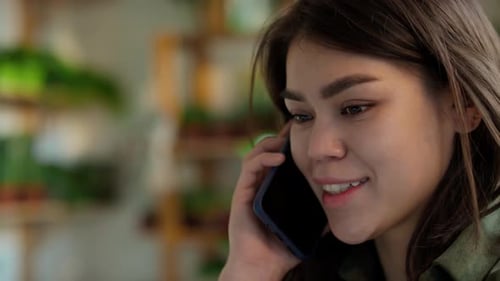 Caucasian Female Sales Assistant Talking on Phone in Garden Centre
