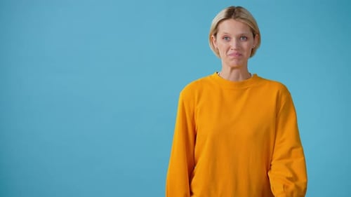 Blonde Woman Pointing to Copy Space in Studio