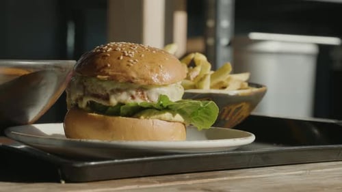 Closeup of a fresh delicious burger with fries in the background
