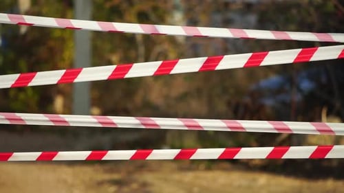 Fita de advertência vermelha e branca balançando no vento