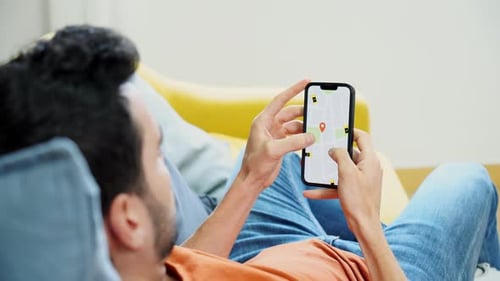 Man Relaxes on Couch, Using Mobile Navigation App