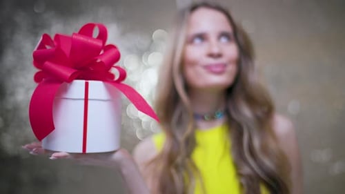 Woman Smiling with Birthday Gift in her Hand