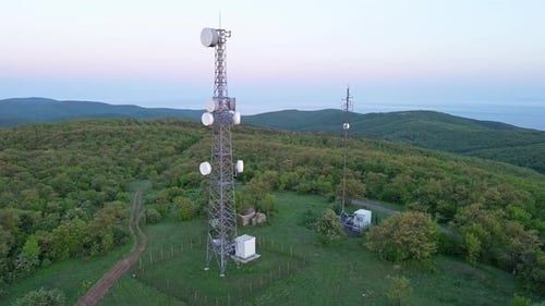 View of the Hills Covered with Vegetation with Cell Towers Against the Backdrop of Fields and a