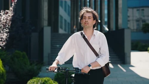 Business Man is Going to the Business Centre Wearing Informal Suit Carrying the Electric Bicycle