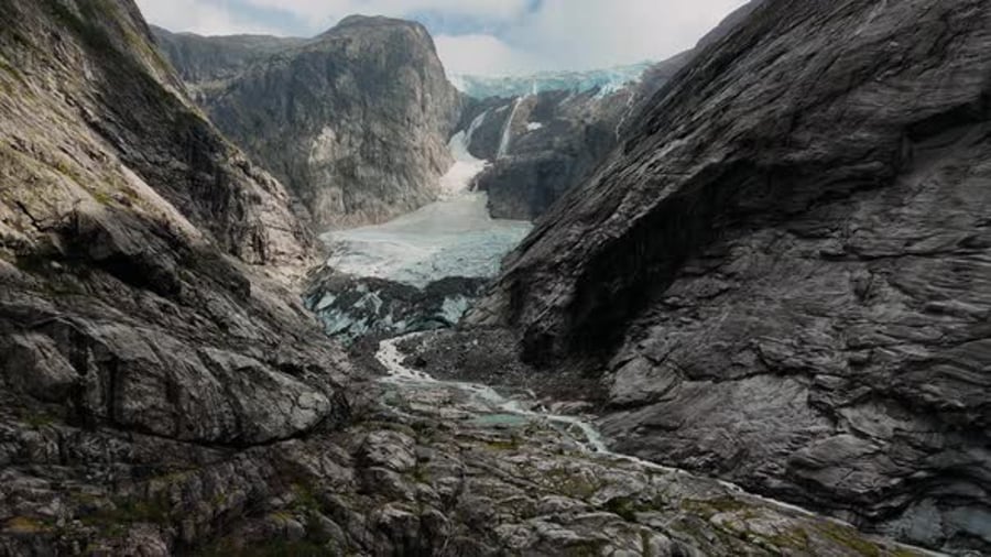 Glacier flowing between steep rock walls with turquoise meltwater ...