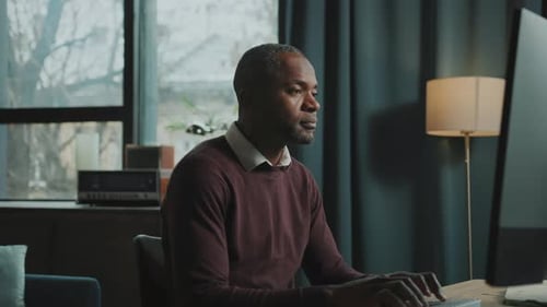Man Typing At Computer In Modern Home Office