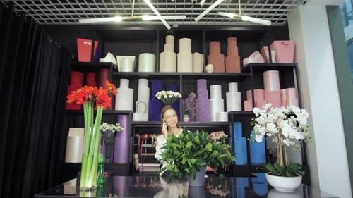 Young Woman Answers Phone in Modern Flower Shop
