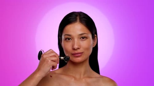Woman Using Facial Roller for Skincare