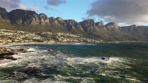 Aerial Panning shot of Cape Town's Camps Bay and Clifton Beaches with Table Mountain and Lion's Head