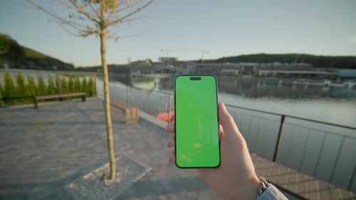 Close Up Young Hands Holding Vertically Phone Smartphone Device with Green Screen Walking On
