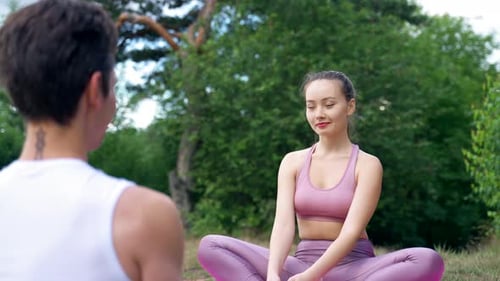 Woman and Man Doing Yoga Outdoors