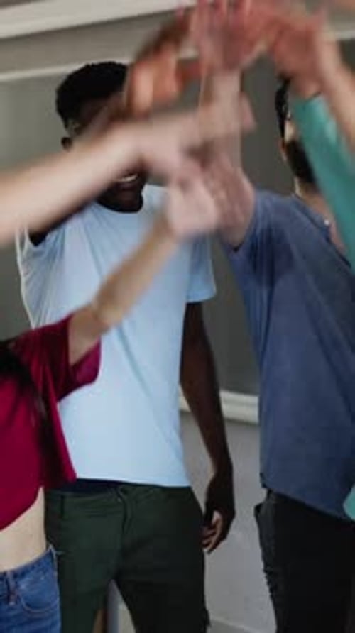 Students and Teacher Hands Together in Classroom