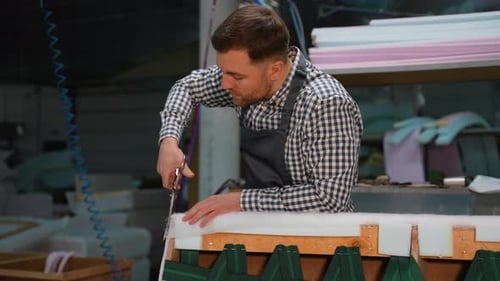 Man Cutting Fabric in Upholstery Workshop