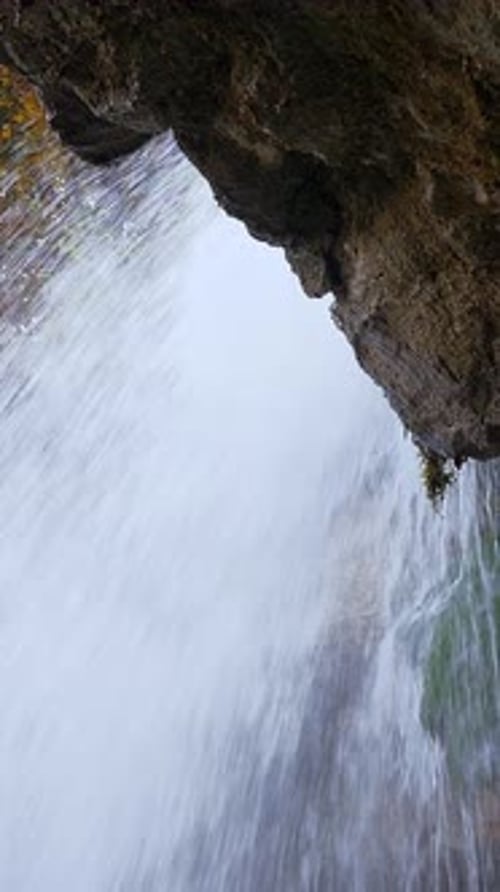 Uma bela cachoeira caindo em cascata sobre uma rocha situada no abraço tranquilo da natureza