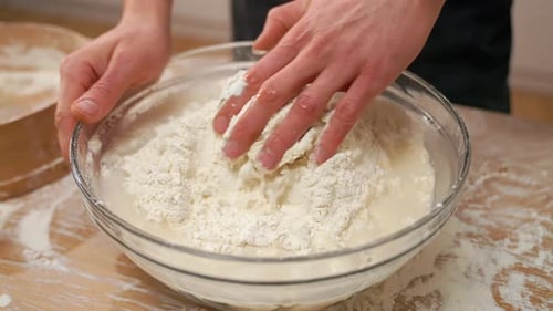 Hands Mixing Flour and Water in a Bowl