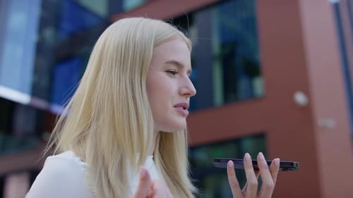 Blonde woman uses voice assistant on mobile device
