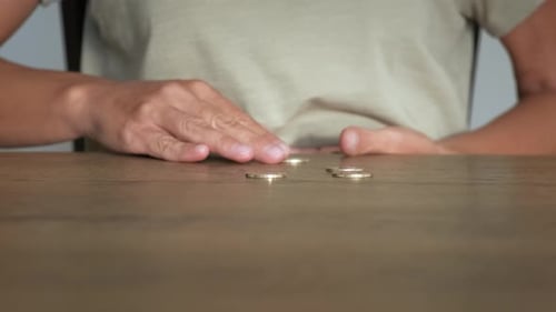 Hands Counting Euro Coins on Wooden Desk