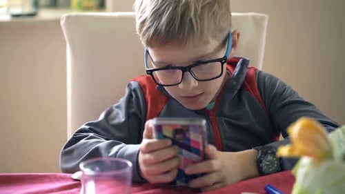 Boy in Glasses Using Mobile Phone Indoors